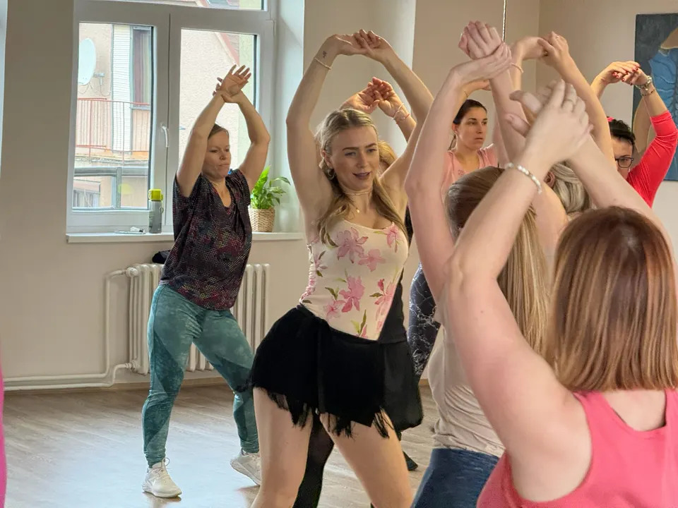 Ženy na workshopu Latino Ladies tančí s rukama nad hlavou